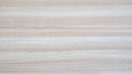 A wooden surface with a grain pattern. The grain is visible in the wood. The surface is light in...