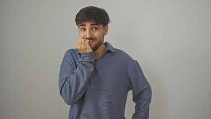 A young bearded man in a blue shirt poses with a pensive expression against a white background.
