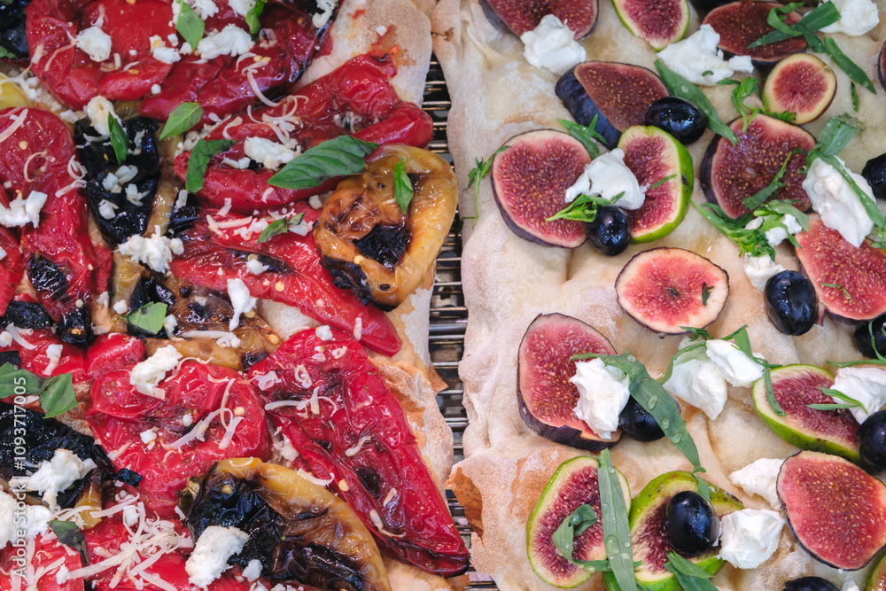 Poster two pizzas with different toppings. one has olives and the other has figs. the fig pizza has a white