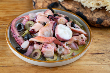 Tasty salad or starter seafood dish, grilled octopus ligurian style with green and black olives served in Italian  restaurant