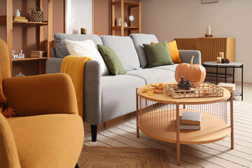 Autumn interior of living room with sofa, armchair, coffee tables and decor