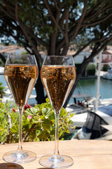 Summer party, French brut rose champagne sparkling wine in flute glasses in yacht harbour of Port Grimaud near Saint-Tropez, French Riviera vacation, Var, France