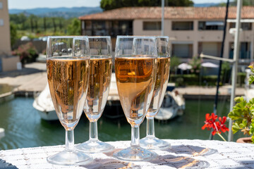 Summer party, French brut rose champagne sparkling wine in flute glasses in yacht harbour of Port Grimaud near Saint-Tropez, French Riviera vacation, Var, France