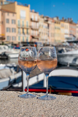 Glasses of cold rose Cote de Provence wine in old fisherman boats and yacht harbour in Saint-Tropez, summer vacation on French Riviera in Provence, France