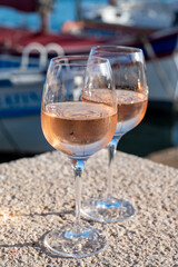 Glasses of cold rose Cote de Provence wine in old fisherman boats and yacht harbour in Saint-Tropez, summer vacation on French Riviera in Provence, France
