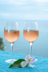 Summer time in Provence, two glasses of cold rose wine with blue sea view on background, French Riviera near Menton, south of France