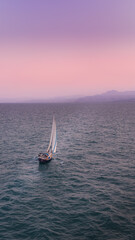 Aerial view of serene sailboats on little wave blue sea