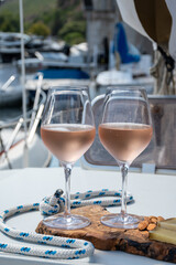 Party with rose wine on yacht boat anchored in port la Rague, Gulf of La Napoule, in Provence, two...