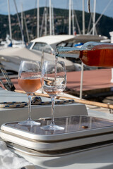 Party with rose wine on yacht boat anchored in port la Rague, Gulf of La Napoule, in Provence, two glasses of cold rose wine, French Riviera near Cannes, south of France