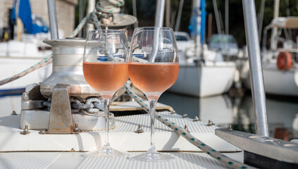 Party with rose wine on yacht boat anchored in port la Rague, Gulf of La Napoule, in Provence, two glasses of cold rose wine, French Riviera near Cannes, south of France