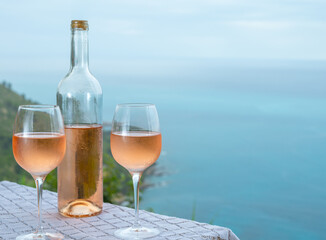 Summer time in Provence, two glasses of cold rose wine with blue sea view on background, French Riviera near Menton, south of France