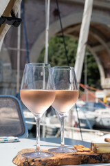 Party with rose wine on yacht boat anchored in port la Rague, Gulf of La Napoule, in Provence, two glasses of cold rose wine, French Riviera near Cannes, south of France