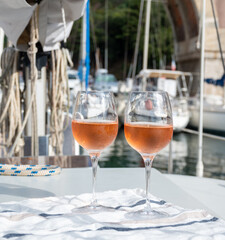 Party with rose wine on yacht boat anchored in port la Rague, Gulf of La Napoule, in Provence, two glasses of cold rose wine, French Riviera near Cannes, south of France