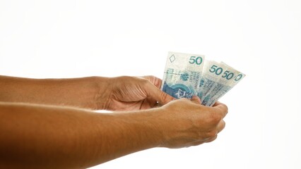 Hands holding fifty zloty polish banknotes over white background, showcasing currency and financial concepts