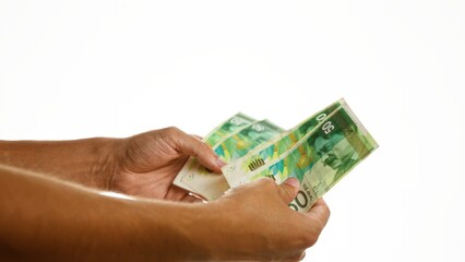 Woman holding israeli shekel banknotes isolated over white background depicting a financial concept...