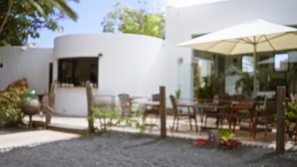 Blurred view of an outdoor seating area in lanzarote, spain with defocused umbrellas, tables, and chairs in the canary islands.