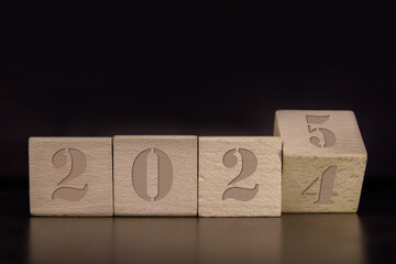 Drewniana kostka. Obrót kostki z 2024 na 2025. Nowy 2025 rok. Nowy rok.