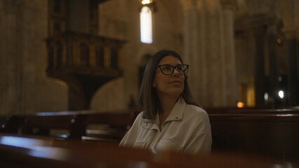 Young hispanic woman sitting in an italian church, contemplating the architectural beauty in a serene christian setting.