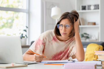 Tired teenage girl filling out college application form at home