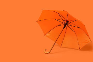 Stylish umbrella on orange background