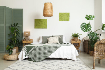 Stylish bedroom with comfortable bed and houseplants