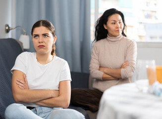 Portrait of two disgruntled girlfriends feeling outraged, quarreling and emotionally gesturing at home