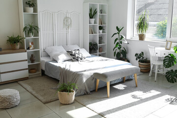 Stylish interior of modern bedroom with houseplants