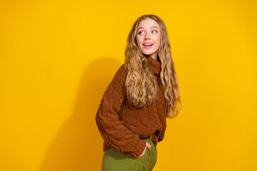 Photo of pretty young woman look empty space wear pullover isolated on yellow color background