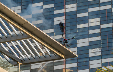 Drone spraying water during fire fighting emergency exercise on modern office building in Amman, Jordan
