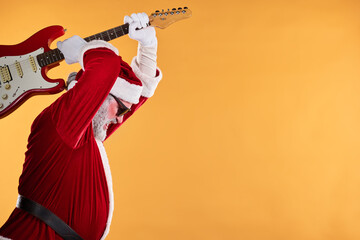 Santa Claus enthusiastically playing an electric guitar in vibrant red outfit. Energetically strumming against a warm background, capturing holiday rock spirit