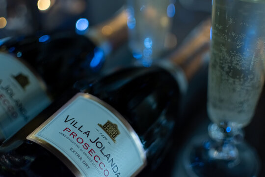 Bottle of Italian white sparkling wine Villa Jolanda Prosecco Extra Dry and flute glasses on blurred festive background with colorful lights. Ukraine, Zhytomyr, November 21, 2024