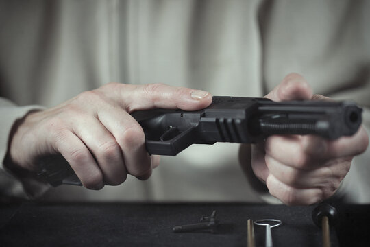 Man take care of semi automatic pistol handgun at home
