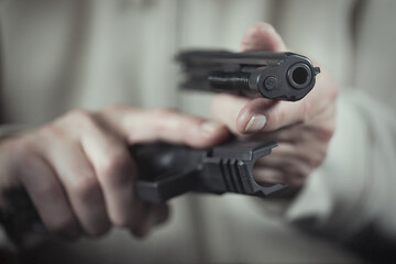 Man take care of semi automatic pistol handgun at home