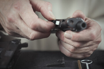 Fototapeta premium Man take care of semi automatic pistol handgun at home