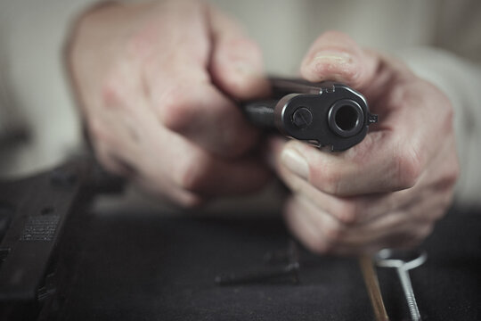 Man take care of semi automatic pistol handgun at home