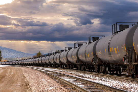 tanker cars of a freight train close to Whitefish, Montana under a beautiful cloudy sky