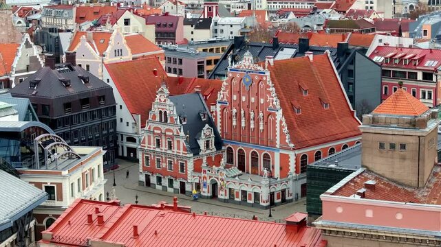 The image shows an aerial perspective of Riga, Latvia, focusing on the House of the Blackheads. The area is filled with colorful European architecture.