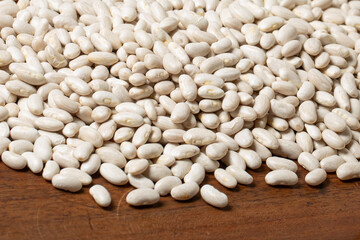 White beans on a spoon on an old wooden table