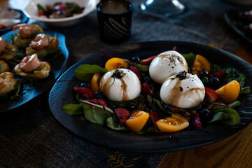 Gourmet Burrata Dish with Fresh Fruits and Greens on Elegant Plate