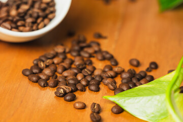 Publicity Day. Colombian coffee. White cup with coffee beans scattered on wooden table with space to copy. Image for advertisement.
