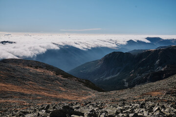 Majestic mountain landscape with a sea of clouds below.  Breathtaking panoramic view of rocky peaks and valleys. Perfect for travel, nature, and adventure themes.