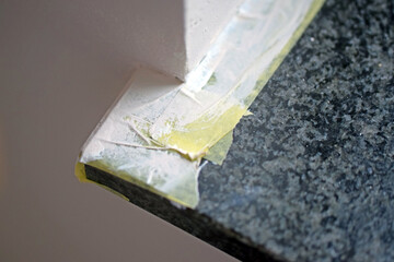 A corner of a window sill taped off with masking tape for painting. 