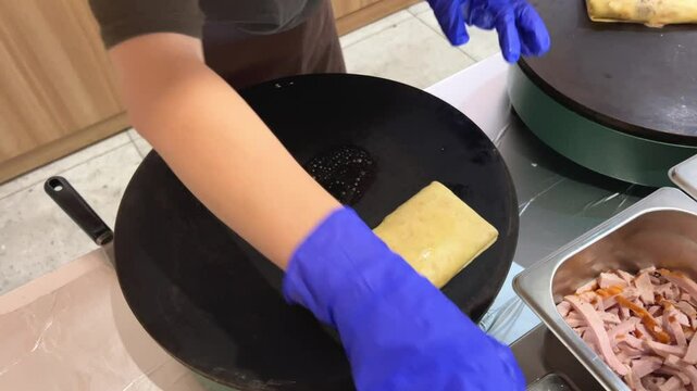 Cook prepares a pancake with a filling. Pancake with meat, cooking process.