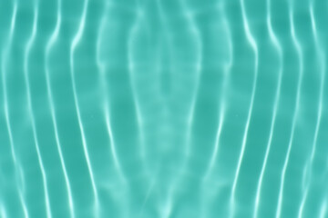 Blue water with ripples on the surface. Defocus blurred transparent blue colored clear calm water surface texture with splashes and bubbles. Water waves with shining pattern texture background.