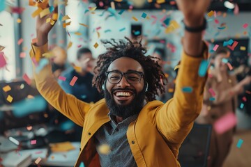 Joyful man celebrating in an office environment with colorful confetti falling around him, expressing happiness and positivity among colleagues