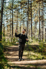 Young caucasian man hiking or trekking through the forest	