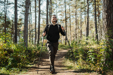 Young caucasian man hiking or trekking through the forest	