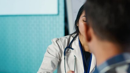 Optometry consultation in a medical office with an indian expert. Professional optometrist provides eye exam, using ophthalmoscope and optical tools to assess eyesight and discuss results. Camera A.