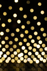 A mesmerizing display of yellow bokeh lights on a black background, creating a vibrant and festive atmosphere.