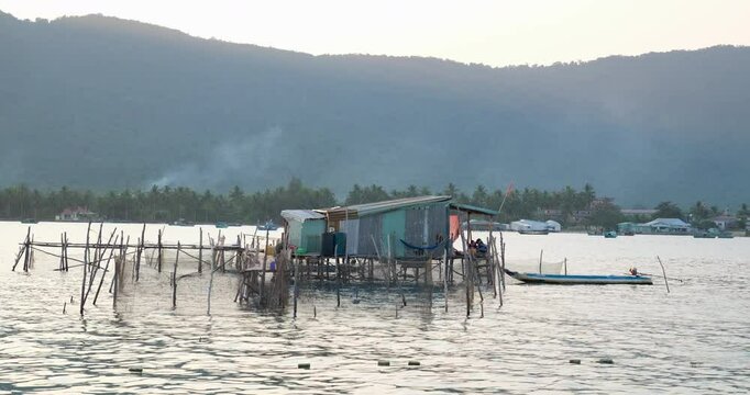 old fisherman's house Sailing past Trunyan village, view of houses, fish farm and temple